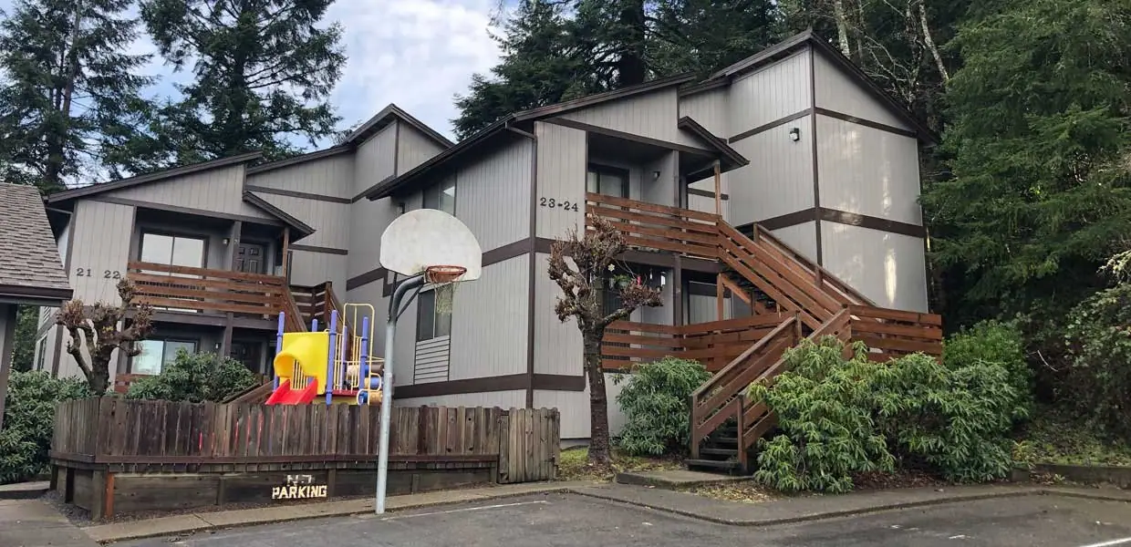 Two-story apartment buildings with wood stair landings and a play area