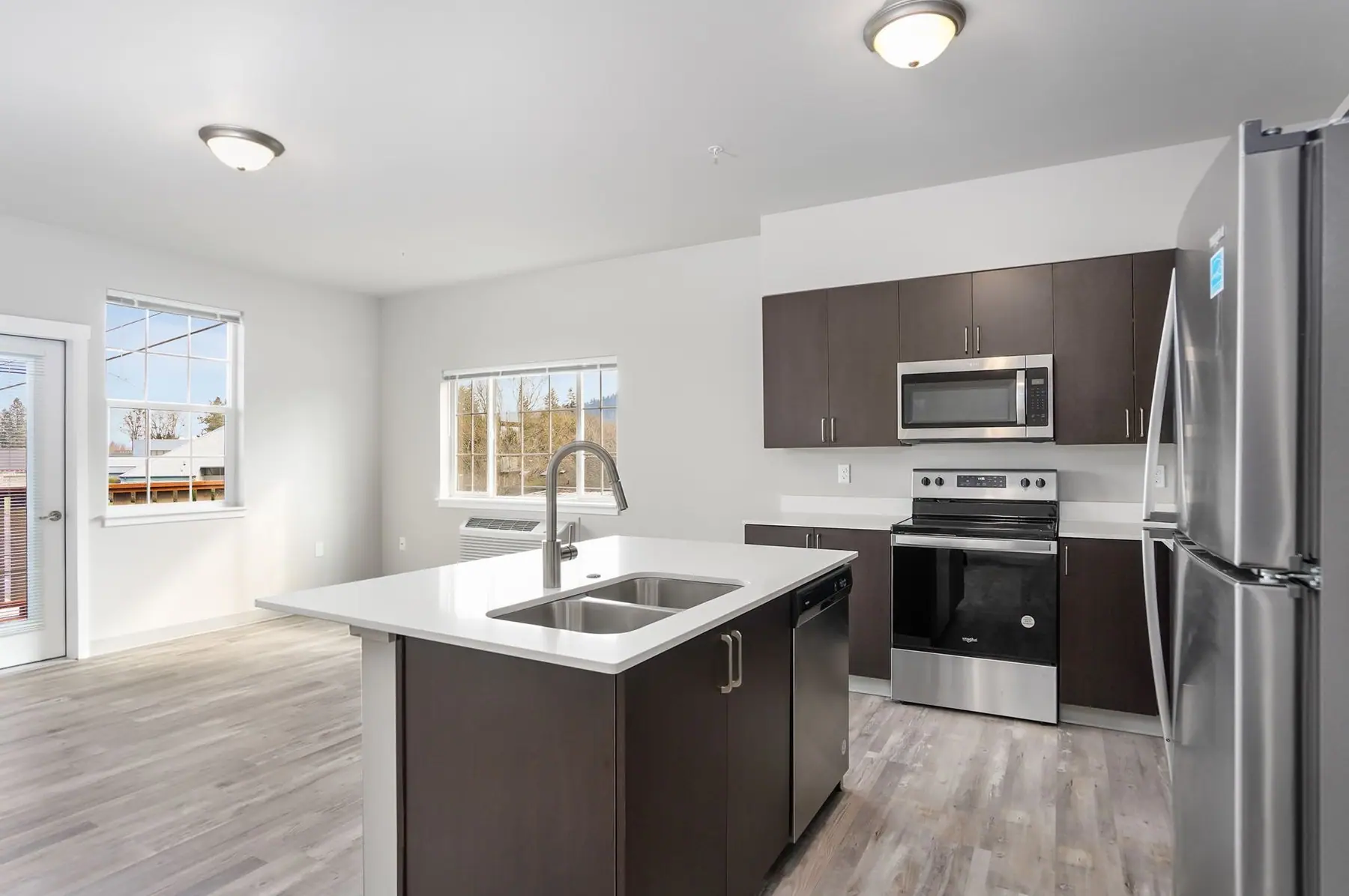 Kitchen at Creekside Crossing with quartz counters, stainless appliances and plank flooring