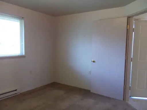 Empty bedroom with carpet and a window