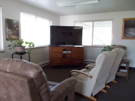 Community room with recliners, a sofa and a television