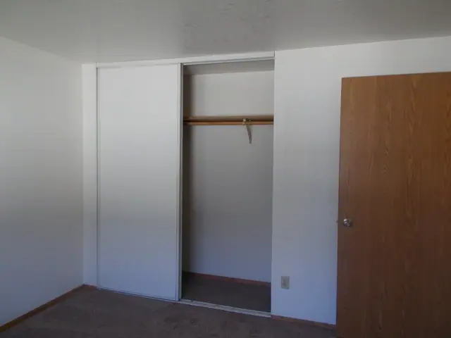 Bedroom closet with a sliding door and a hanging rod
