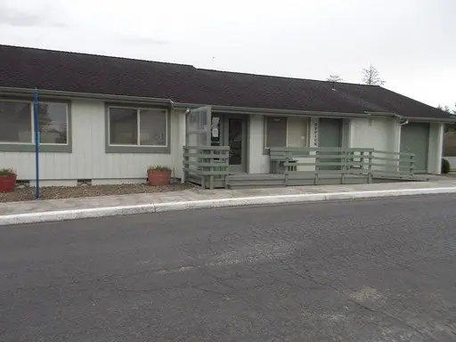 Single-story building with front railings by the parking lot