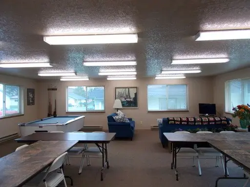 Community room with a pool table, sofas and folding tables