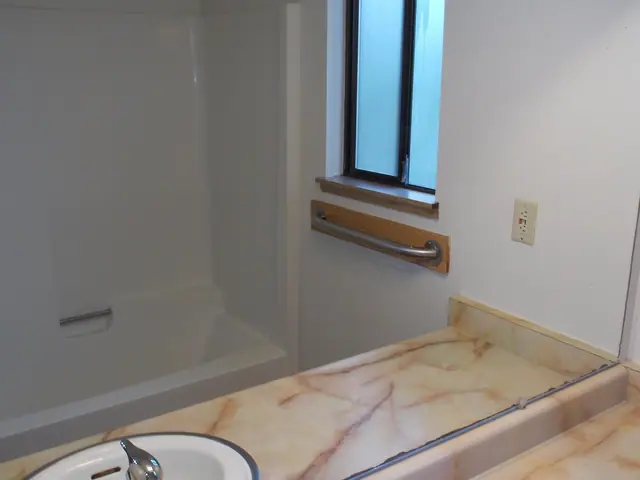 Bathtub with a grab bar and a marbled vanity counter