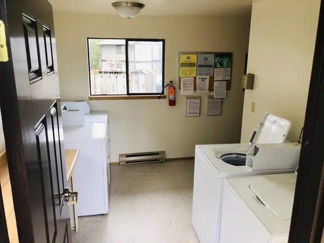 Laundry room with washers, dryers and a notice board