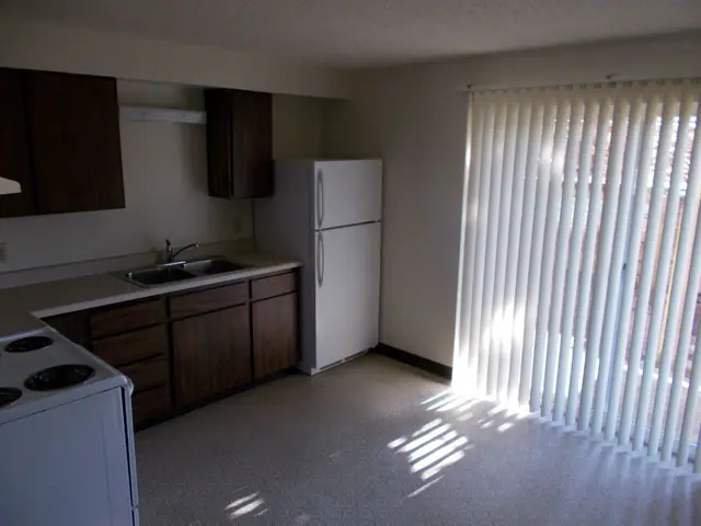 Kitchen with dark wood cabinets, a refrigerator and a sliding door