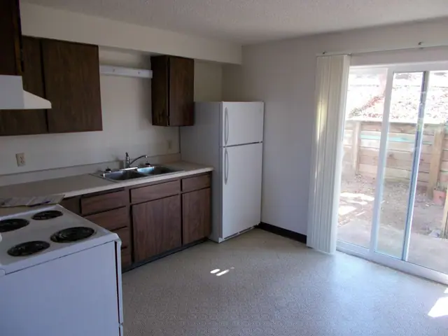 Kitchen with dark wood cabinets beside a sliding glass door