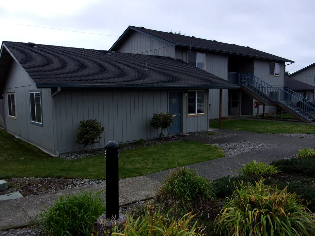 Gray buildings with outside stairs and landscaped beds