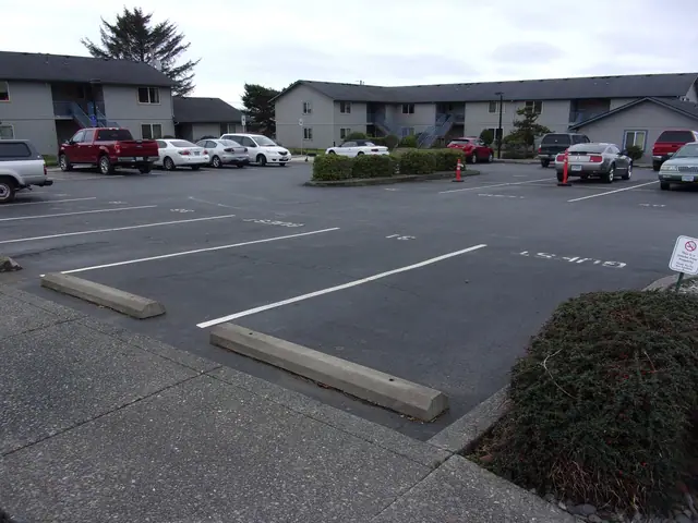 Parking lot in front of two-story gray buildings