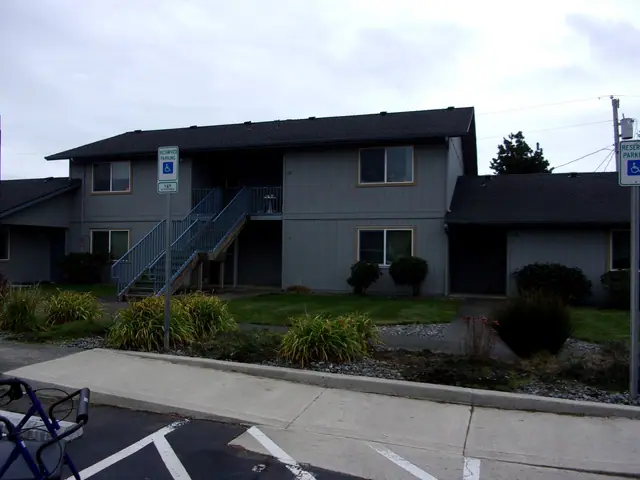 Two-story gray building with outside stairs and accessible parking