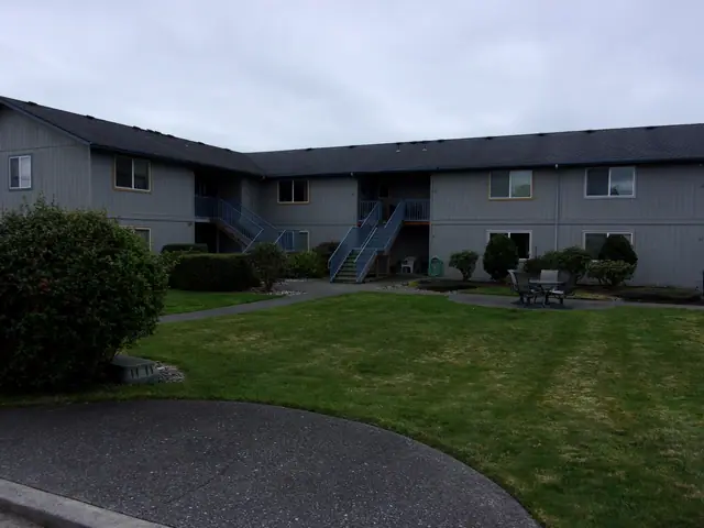 Courtyard lawn with a picnic table between two-story buildings