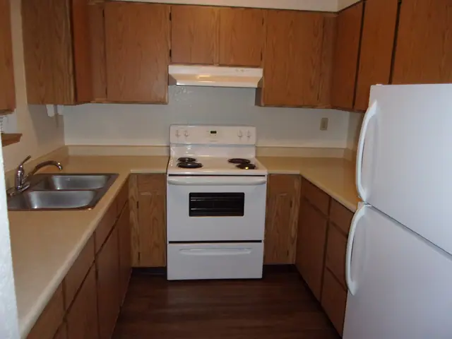 Kitchen with wood cabinets, a double sink and an electric range