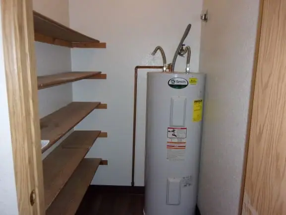 Storage closet with shelves and a water heater