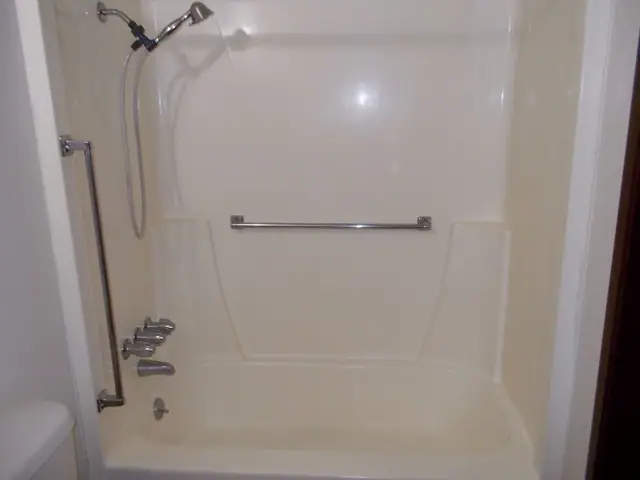 Bathtub with grab bars and a hand-held shower