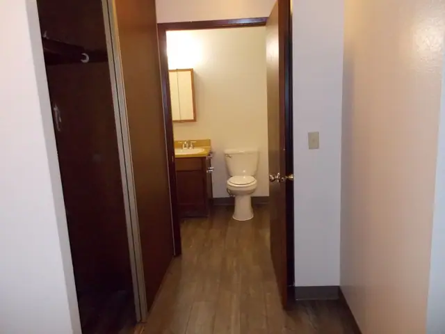 Bedroom closet beside the open bathroom door