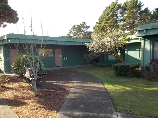 Building with pink doors, a bench and a curved walkway