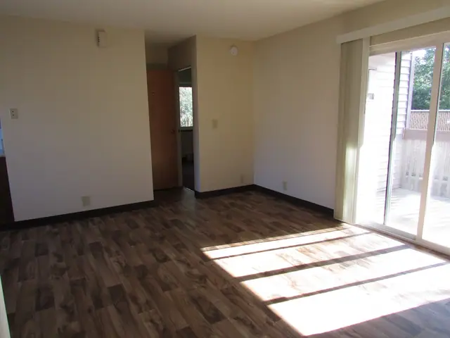 Living room with wood-look flooring and a sliding door