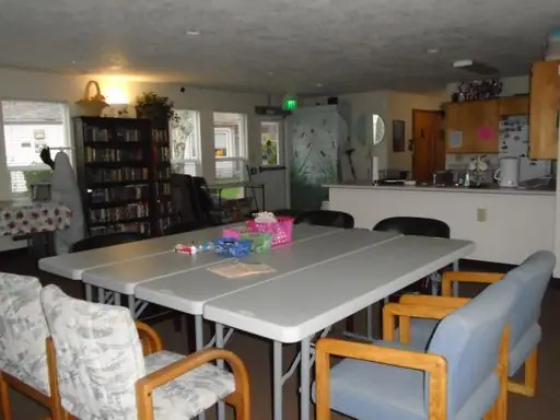 Community room with tables, chairs and bookshelves