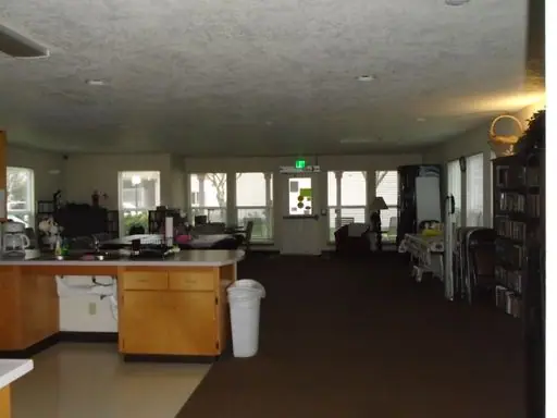 Community room with a kitchen counter, a bookcase and windows