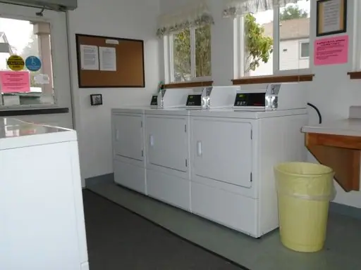 Laundry room with three dryers by the windows