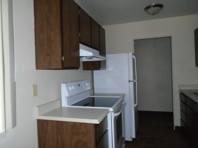 Kitchen with wood cabinets, a glass-top range and a refrigerator