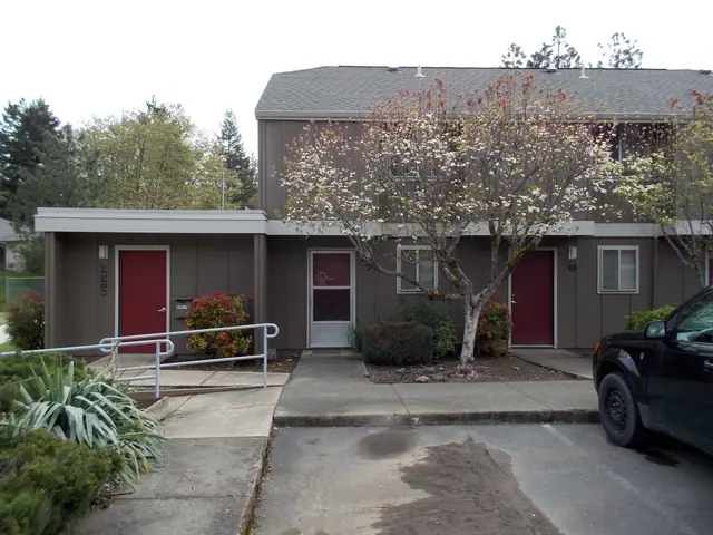 Two-story building with red doors and a ramp with handrails