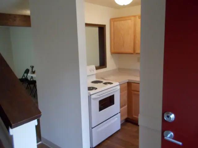 Entry by the stairs, with the kitchen beyond