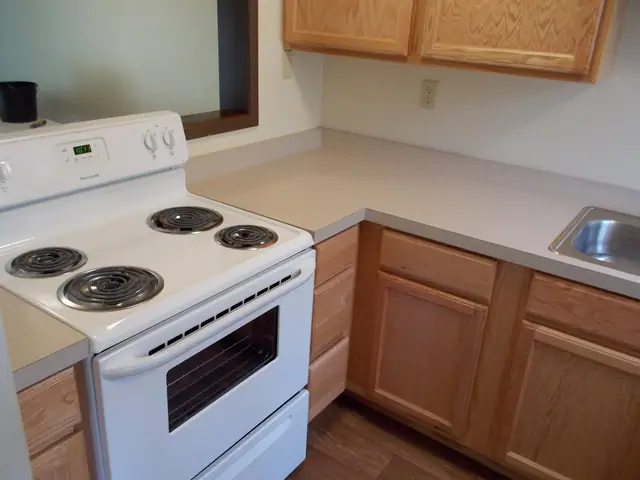 Kitchen with an electric range and light wood cabinets