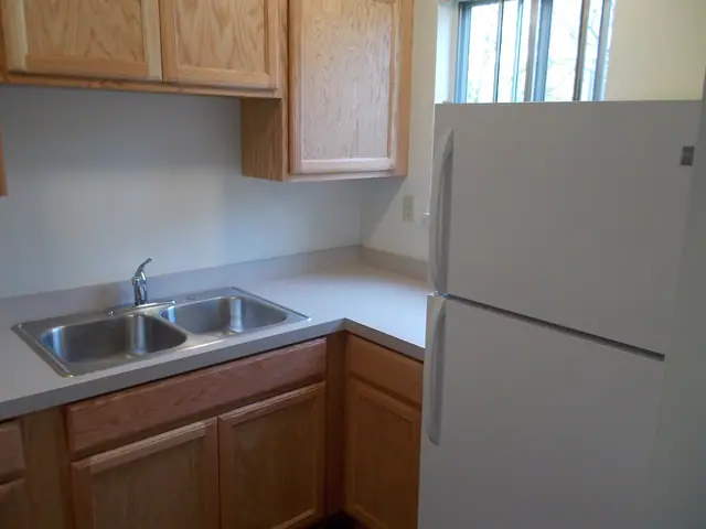 Kitchen with a double sink, wood cabinets and a refrigerator