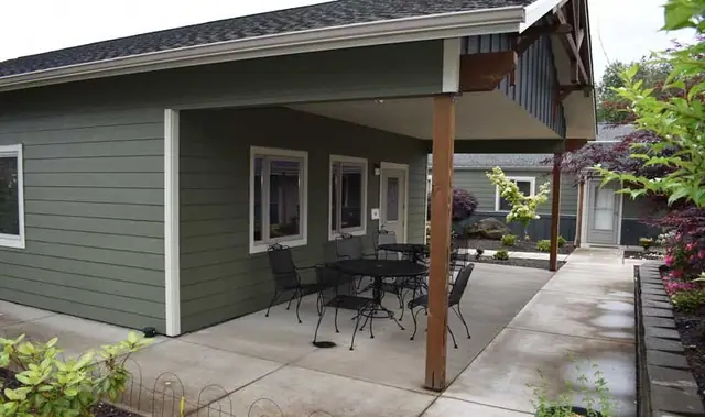 Covered patio with tables and chairs along the building