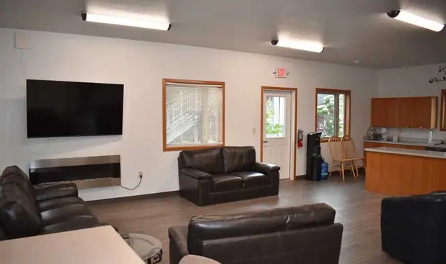 Community room with a television, sofas and a kitchen